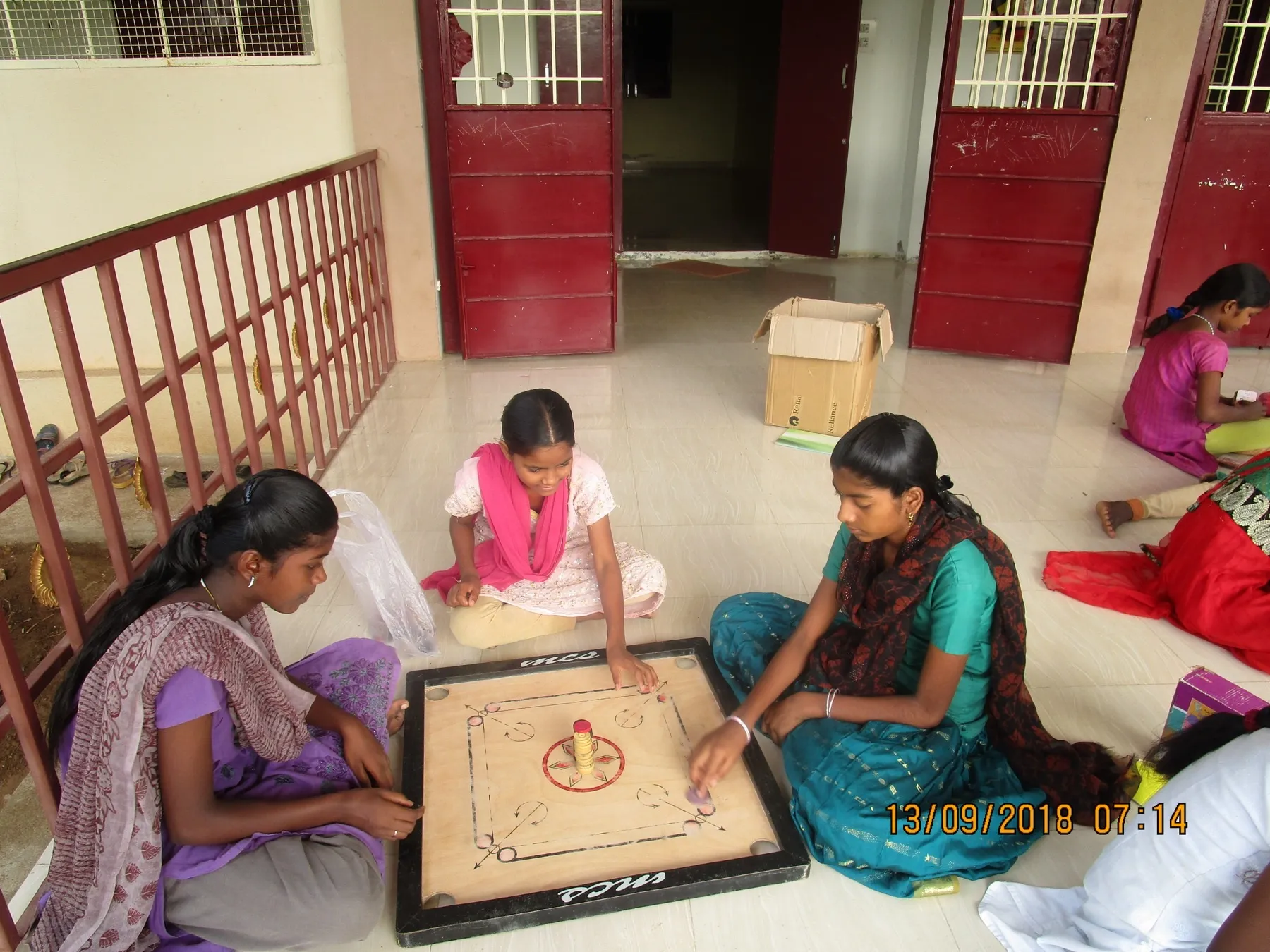 Partita a carrom, il gioco da tavolo indiano, seduti per terra